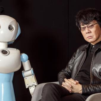 Ishiguro poses with the humanoid robot Robovie.
