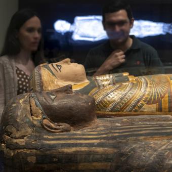 Visitantes observan una de las piezas expuestas en Momias de Egipto, una de las muestras más concurridas en CaixaForum Sevilla.