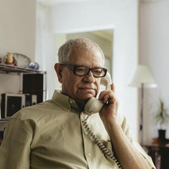 Una persona mayor hablando por teléfono. 