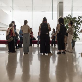 Un grup de persones cuidadores al hall de CaixaForum Barcelona.