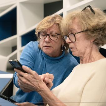 Dos señoras aprenden a utilizar un smartphone durante los talleres Competencias Digitales +60. 
