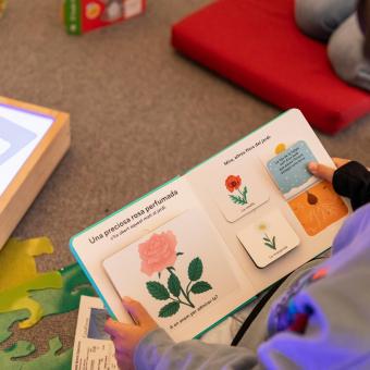 Un niño sentado leyendo atentamente un libro.