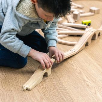 A child assembling a toy car track in the CaixaProinfancia 3-6 Growth Spaces at the Barró Association.