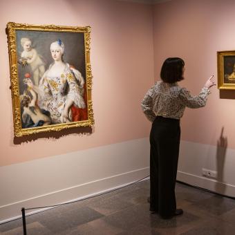 Una dona admirant algunes de les obres presents a l'exposició «La botànica en l'art» a CaixaForum Girona.