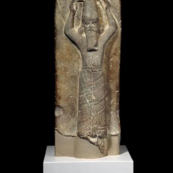 Estela de arenisca roja, con Asurbanipal transportando una cesta ritual de tierra sobre la cabeza para la reconstrucción de E-Zida, 668-655 a. de. C., templo de Nabu, Borsippa (Irak). 1880,0617.2.
