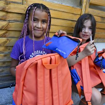 Dos niñas usuarias del programa CaixaProinfancia con su nuevo material escolar. 