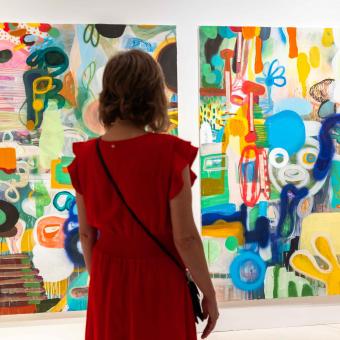 Una mujer admirando algunas de las obras expuestas en la muestra «Rumores infundados. Javier y Rafa Forteza» en CaixaForum Madrid.