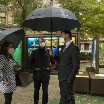 De izquierda a derecha: la directora Territorial Ebro de CaixaBank, Isabel Moreno, el director de la Fundación Caja Navarra, Javier Fernández Valdivieso, y el comisario de la muestra, Javier Gómez, comentando la exposición De Polo a Polo, un viaje a los grandes paraísos naturales.