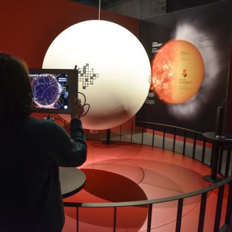 Visitors in the augmented reality installation to learn about the internal processes of the Sun.