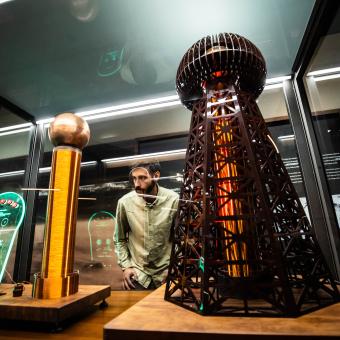 Un visitante observa uno de los módulos de la exposición sobre Nikola Tesla en CaixaForum Madrid.