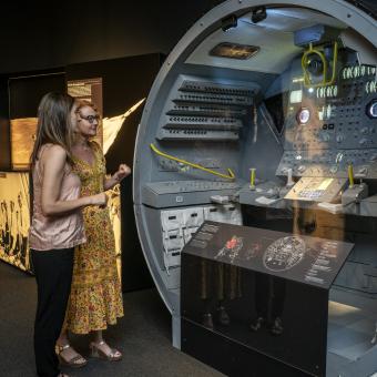 Unas visitantes observan una réplica del módulo lunar en la muestra sobre el Apollo 11 en CaixaForum Palma.