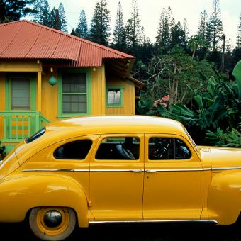 A bright yellow Plymouth is parked in front of a matching Lana’i City cottage. Most of the island’s 2,800 Lana’i City residents continue to live in pastel-painted, tin-roofed cottages that housed them when they worked on the island’s pineapple plantations. Lanai island, Hawaii, USA. © Jim Richardson/ National Geographic.