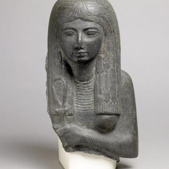 Representación de una mujer sosteniendo un sistro decorado con el rostro de Hathor, c. 1292-1189 a. C., Basalto, Egipto. 1853,0822.3.