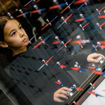 Nena en el mòdul “Forces invisibles” de l’àmbit Kosmos de la Sala Univers de CosmoCaixa. 