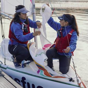 Dos chicas del programa ESFUERZA de la Fundación María José Jove preparando el barco de vela para salir a navegar.