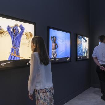 Visitantes observan el ámbito Azul de la exposición Colores del mundo en CaixaForum Sevilla