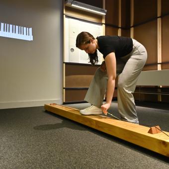 A visitor plays the monochord at the exhibition.