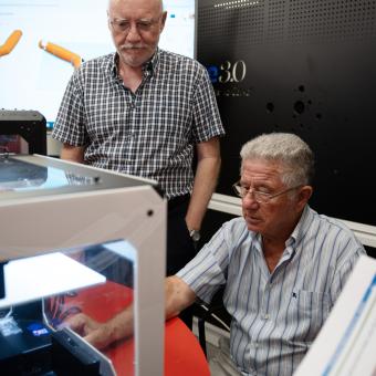 Personas mayores en el taller de impresión 3d.