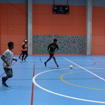 Personas migrantes jugando a fútbol.