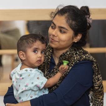 A mother holds her child in her arms.