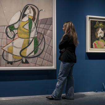 Una visitante observando dos pinturas de la exposición «Arte y naturaleza. Un siglo de biomorfismo».