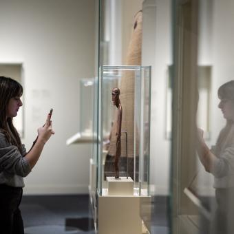 Una visitante fotografía una de las esculturas de la muestra.