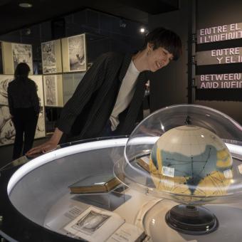 Una visitante contempla los libros históricos que contiene la exposición.