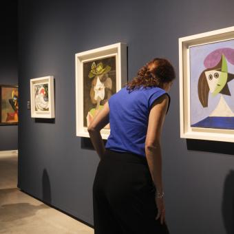 Dos visitantes admiran algunos de los cuadros de la exposición «Arte y naturaleza. Un siglo de biomorfismo» en CaixaForum Sevilla.