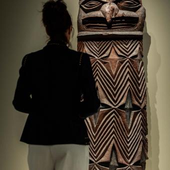 Una visitante admirando una de las esculturas de la muestra «Voces del Pacífico» expuesta en CaixaForum Madrid.