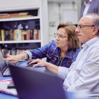 Un senyor i una senyora aprenent més sobre les noves tecnologies.