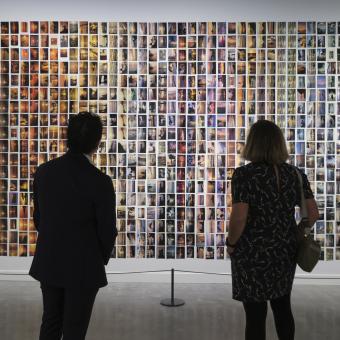 Tres persones visitant una exposició.