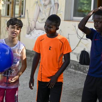 Tres niños beneficiarios del programa CaixaProinfancia de la Fundación ”la Caixa” jugando con una pelota.