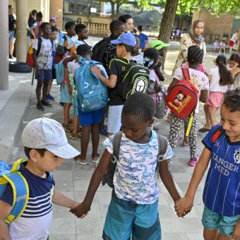 Tres amigos cogidos de la mano disfrutando del verano gracias al programa CaixaProinfancia de la Fundación ”la Caixa”.