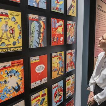 Una visitant de l'exposició «Còmic. Somnis i història» observant les diverses portades de l'icònic «Tintin». 