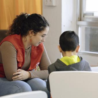 Educadora de CaixaProinfancia atendiendo a niños en la entidad Save The Children.