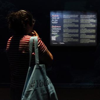 Una persona en una de les sales dʼexposició «Som Natura» a CaixaForum Barcelona.