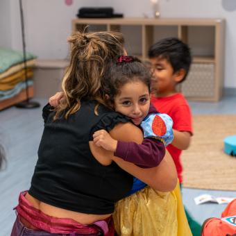 Una niña abrazando a una de las educadoras de CaixaProinfancia en la entidad Gazteleku de Bilbao.