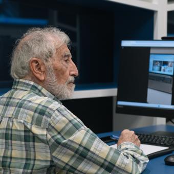 Un señor utilizando las redes sociales en un ordenador. 