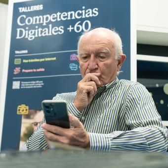 Un señor practica con el móvil durante los talleres Competencias Digitales +60.