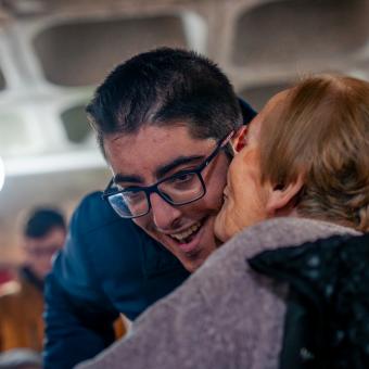 Luisa le da un beso al voluntario que la acompaña, Adrián. 