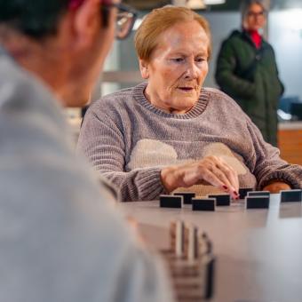Luisa jugando al dominó con Adrián.