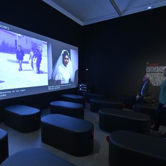 Una visitante disfrutando de una de las piezas audiovisuales de la muestra Recuerdos. La vida a través del cine doméstico en CaixaForum Barcelona. 