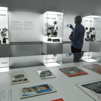 Un hombre fotografía una de las piezas expuestas en la muestra Recuerdos. La vida a través del cine doméstico en CaixaForum Barcelona. 