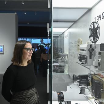 Una mujer observa las diversas cámaras de la muestra Recuerdos. La vida a través del cine doméstico en CaixaForum Barcelona. 