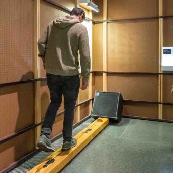 Dos visitantes interactúan con el monocordio gigante de la muestra.