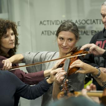 Violinista junto a personas sordas en las sesiones preparatorias del concierto.