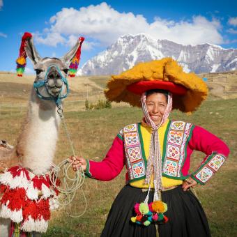 Santusa sonríe con alegría junto a una llama, reflejando las actividades cotidianas que realizan las mujeres en las comunidades, experiencias que comparten con los visitantes.