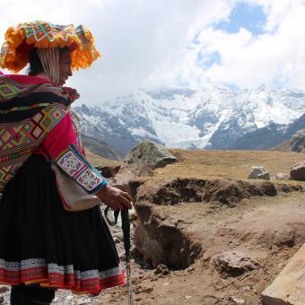 Inocencia, orgullosa, muestra su traje y su vida cotidiana como pobladora, en medio del majestuoso paisaje del Ausangate.