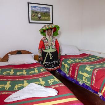 Emiliana muestra con orgullo las camas del alojamiento en la comunidad de Upis, donde reciben a los visitantes que recorren la ruta del Ausangate.