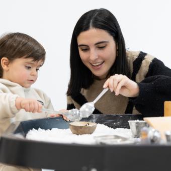 Una mare usuària del programa CaixaProinfància de la Fundació ”la Caixa” cuinant amb la filla.